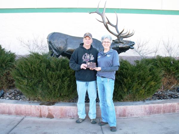 Randy Piearson, President of the Headwaters Chapter, presents Dianna Berry, an assistant manager at Sportsmans Warehouse in Helena, with a major sponsor appreciation plaque.